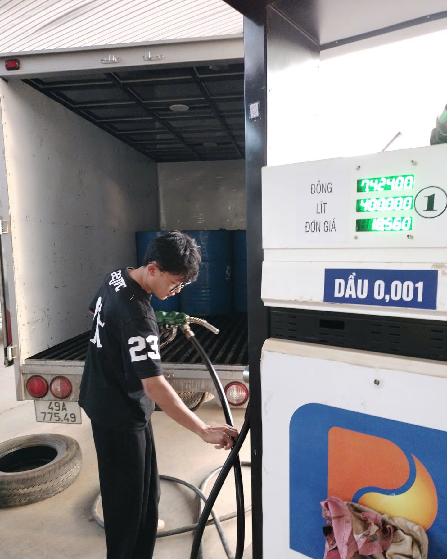 Hồ Lê Thanh Hoàng cầm vòi bơm nhiên liệu tại một cửa hàng xăng dầu